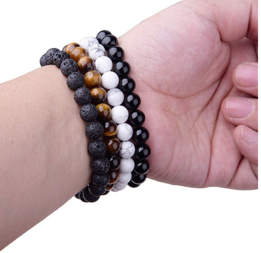 Superposition de bracelets de pierre dont l'agate noire