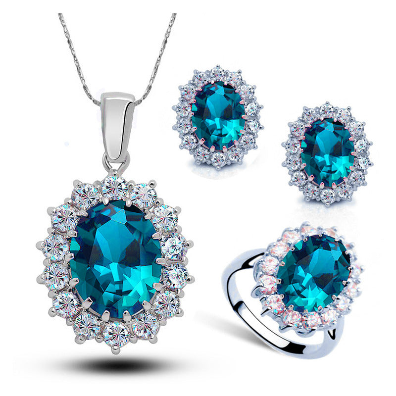 Parure argentée à cristal vert : pendentif, boucles d'oreilles et bague