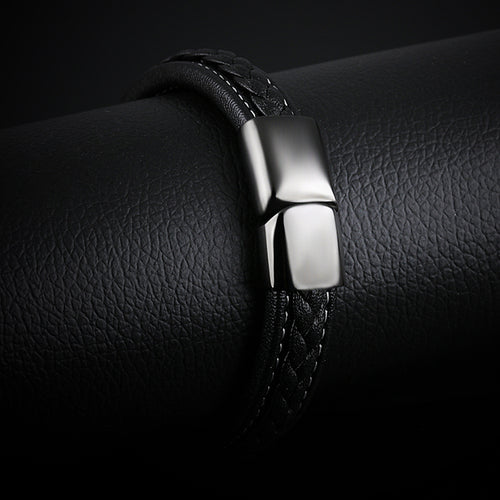 Bracelet Corsaire porté au poignet, cuir noir tressé