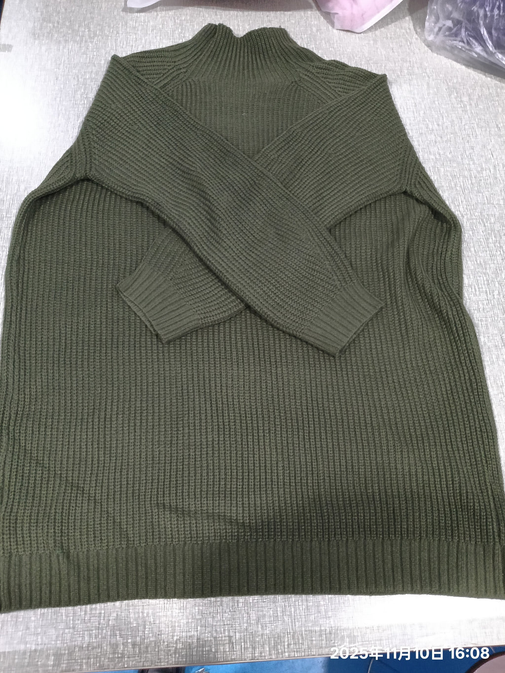 Robe pull vert kaki présentée à plat, maille côtelée visible