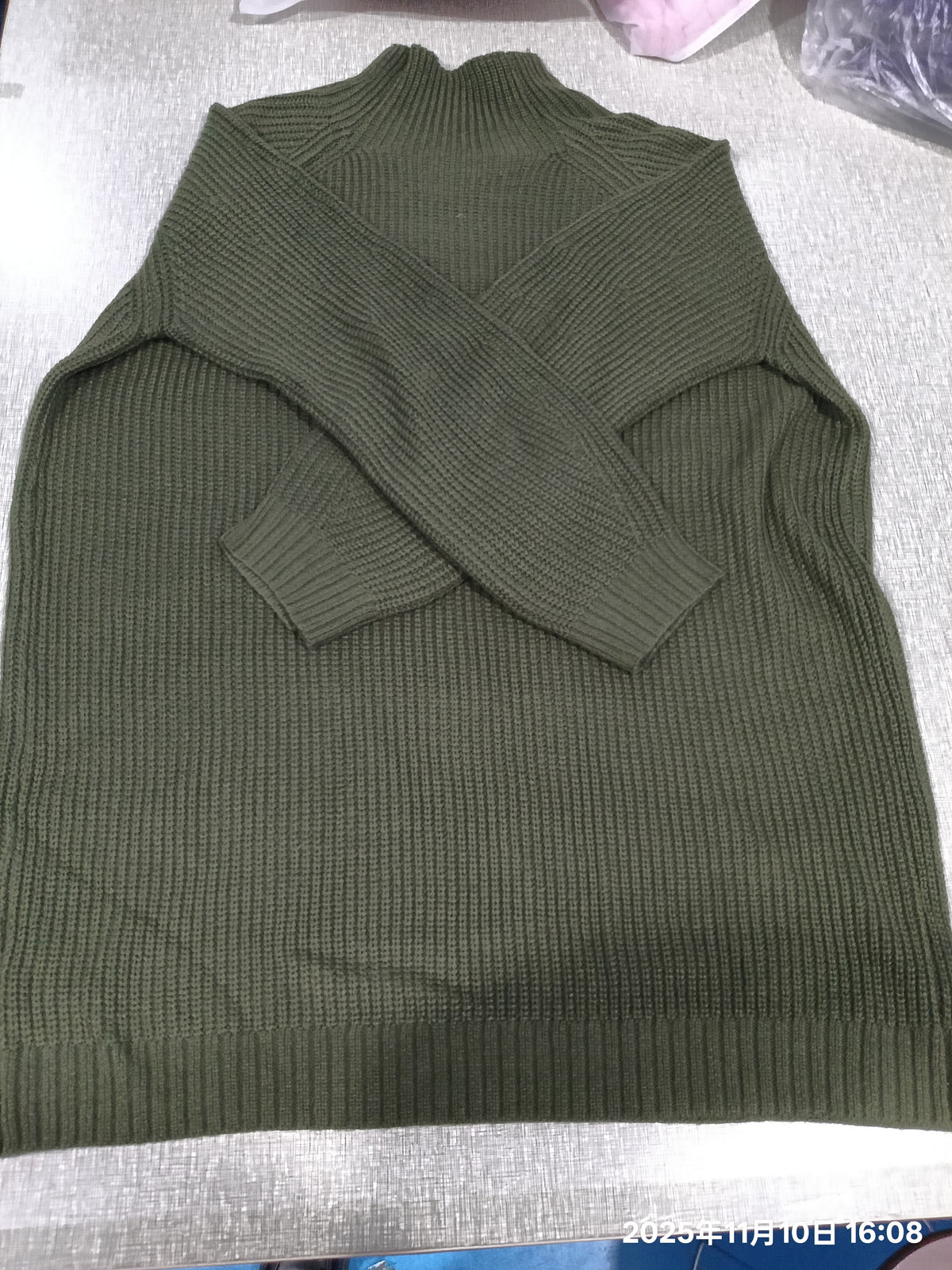 Robe pull vert kaki présentée à plat, maille côtelée visible