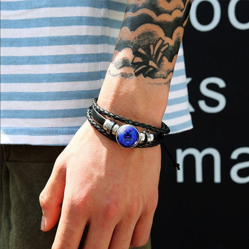 Bracelet zodiaque posé sur bois sombre, cabochon et perles d'acier