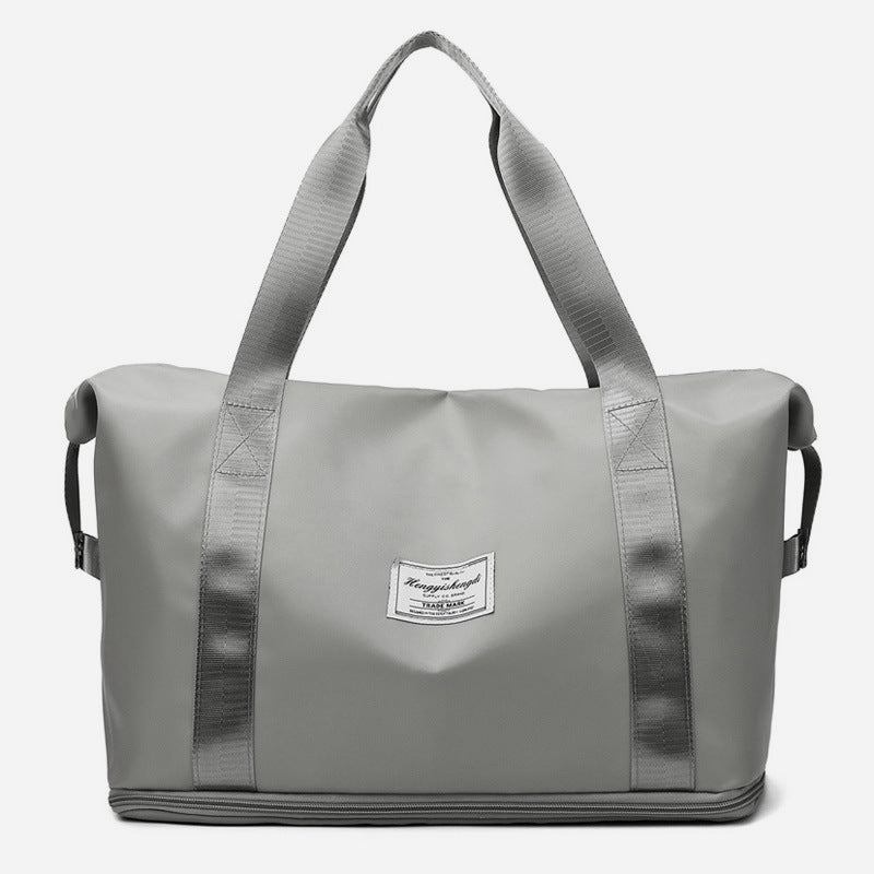 Sac de sport fixé sur la poignée d'une valise