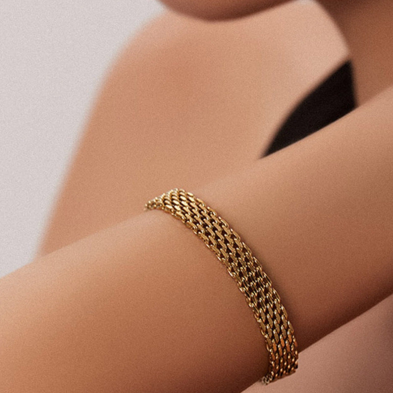 Bracelet maille doré porté au poignet