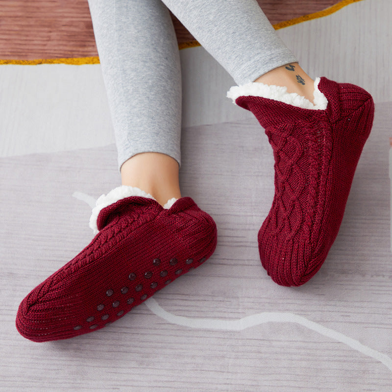 Chaussons-chaussettes bordeaux portés sur un tapis