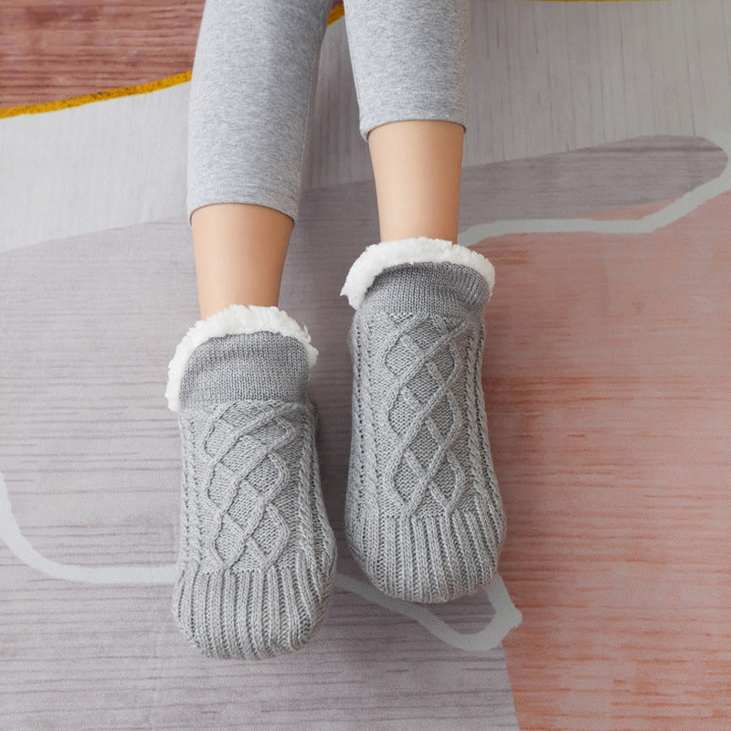 Chaussons-chaussettes, portés sur un parquet