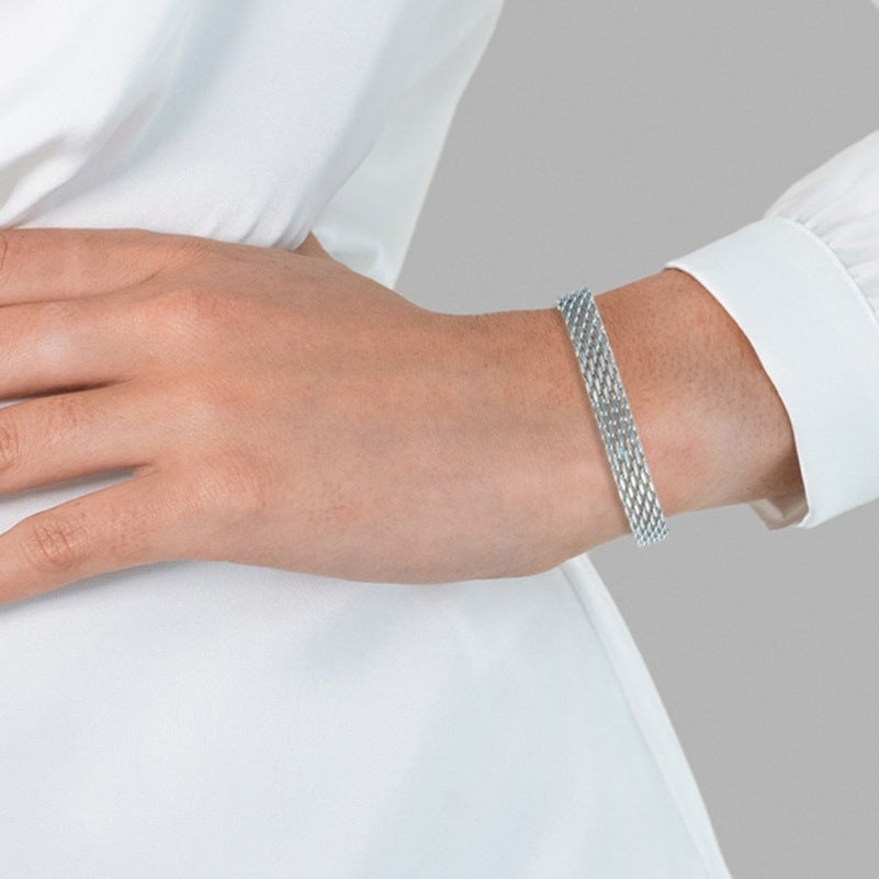 Bracelet maille porté au poignet avec une chemise blanche