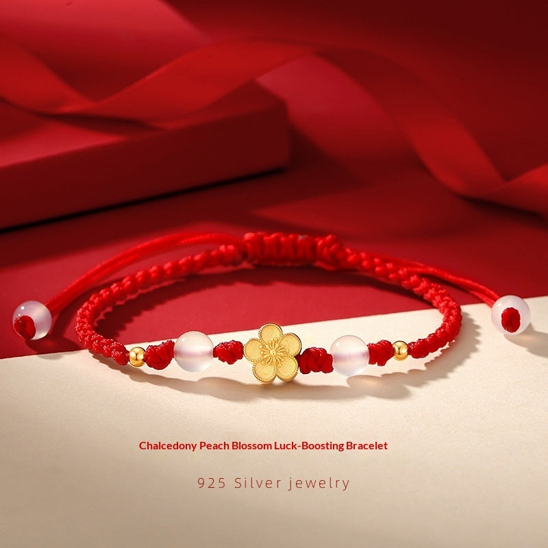 Bracelet Fleur de Pêcher porté au poignet, cordon rouge